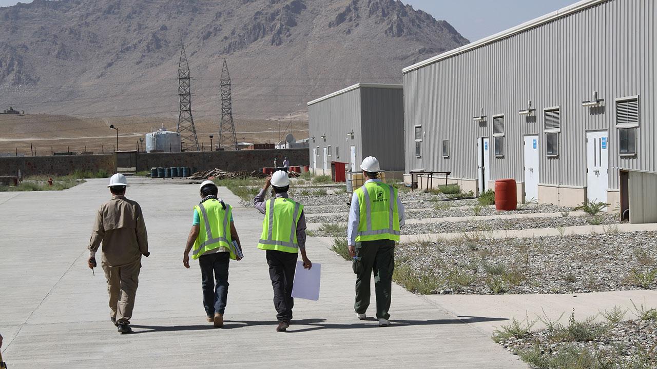 Four Tetra Tech staff are walking together on site at an electrical engineering project